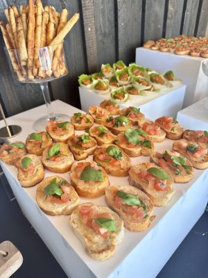 Bunt belegte Canapés in Reihen auf weißen Buffetpodesten